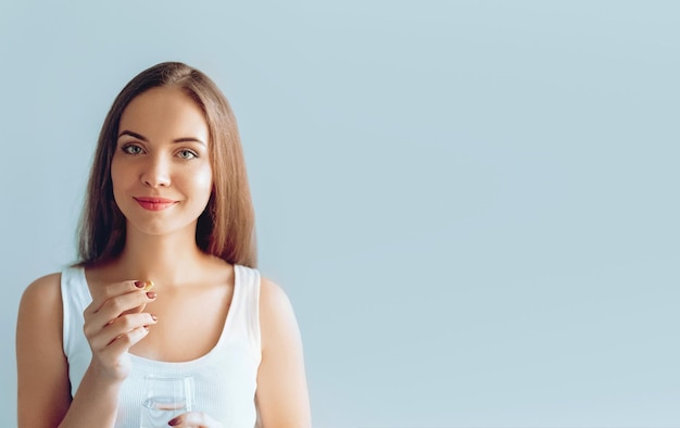 Linda mulher sorridente tomando suplemento dietético de pílula de vitamina