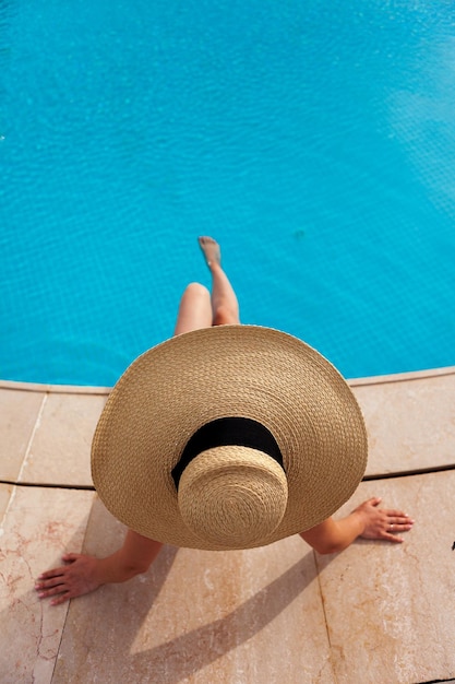 Linda mulher tomando banho de sol à beira da piscina vista superior horizontal cartaz de fundo de verão simulado para design