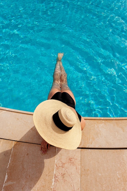 Linda mulher tomando banho de sol à beira da piscina vista superior horizontal cartaz de fundo de verão simulado para design