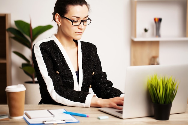 Linda mulher trabalhando no laptop no escritório