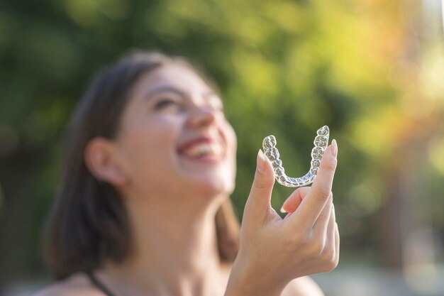 Linda mulher turca sorridente está segurando uma braçadeira invisalign