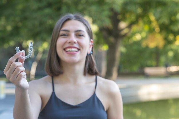 Linda mulher turca sorridente está segurando uma braçadeira invisalign