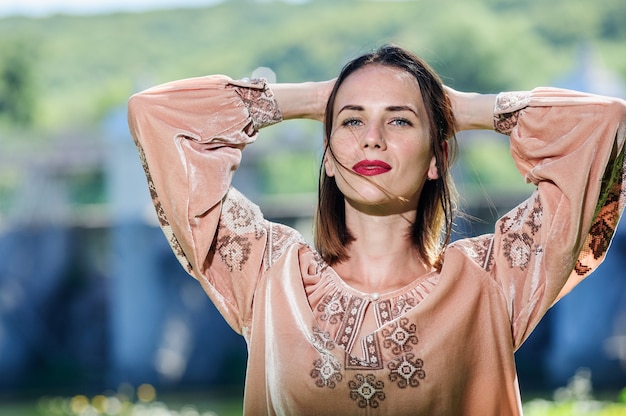 Linda mulher ucraniana yang vestida com um vestido étnico moderno tradicional.