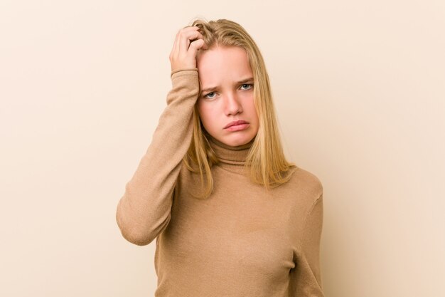 Linda y natural adolescente mujer cansada y con mucho sueño manteniendo la mano en la cabeza.