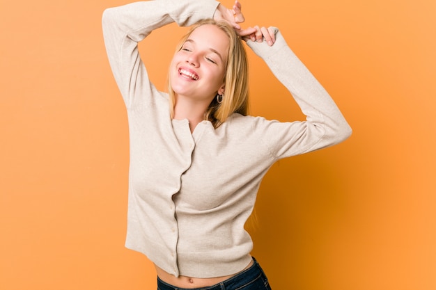 Linda y natural adolescente mujer estirando los brazos, posición relajada.