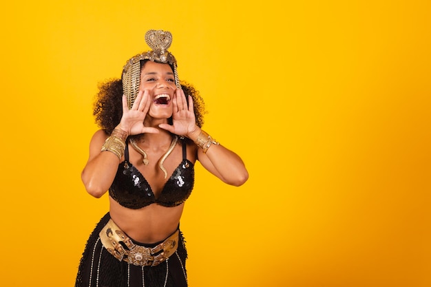 Linda negra brasileira em roupas de carnaval de Cleópatra gritando promoção de publicidade