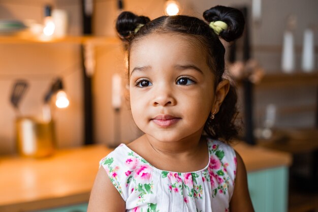 Linda niña afroamericana en casa en la cocina