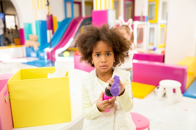 Linda niña afroamericana en sala de juegos