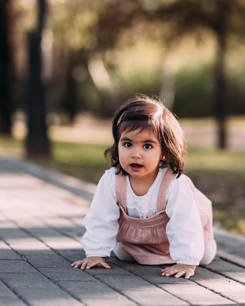 Linda niña arrastrándose en un parque