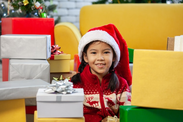 Linda niña asiática con cajas de regalo y decoración para celebrar el festival de Navidad