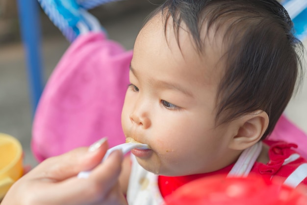 Linda niña asiática comiendo arroz con mamá, gente de Tailandia, hora de comer