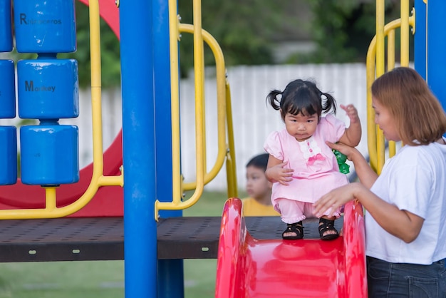 Linda niña asiática juega en el patio de recreoGente de TailandiaConcepto de niño feliz