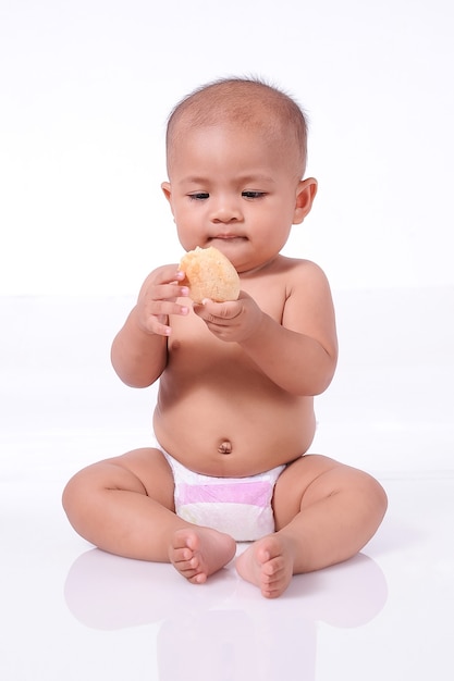 Linda niña asiática vistiendo pañal con galleta