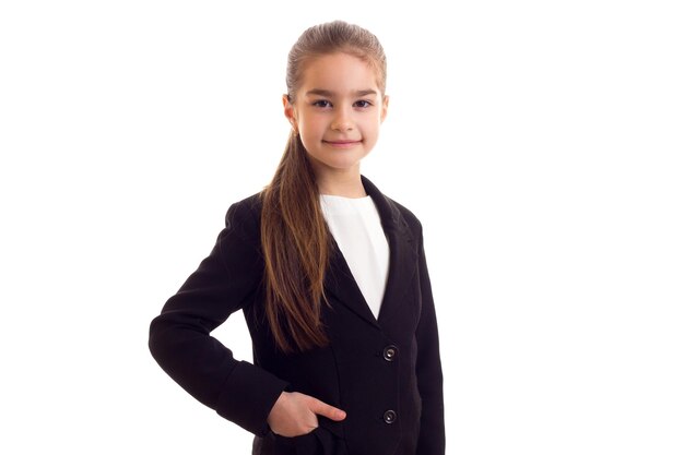 Niña linda en una camiseta negra sobre un fondo blanco.