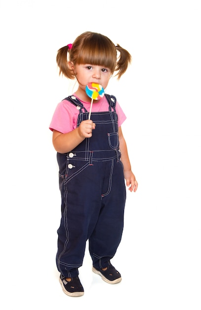 Linda niña comiendo una paleta de colores