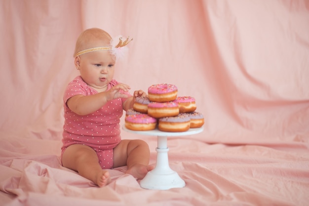 Linda niña comiendo sabroso donut glaseado