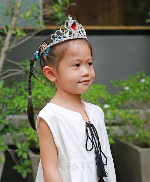 Linda niña con una corona y un vestido blanco linda sonrisa