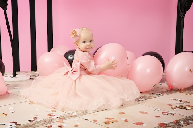 Linda niña de cumpleaños jugando con globos en la fiesta