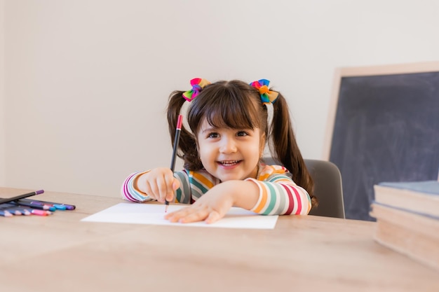 Linda niña dibuja con lápices de colores