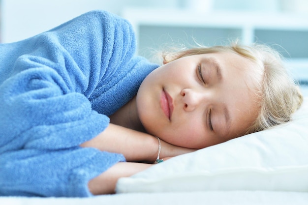 Linda niña durmiendo en la cama