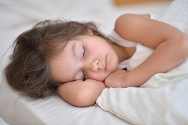 Linda niña durmiendo en la cama