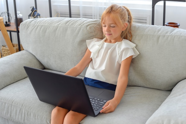 linda niña estudiante haciendo la tarea en casa en línea