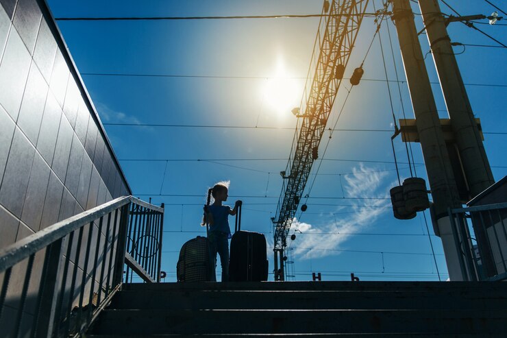 Foto linda niña con grandes maletas en una estación de ferrocarril