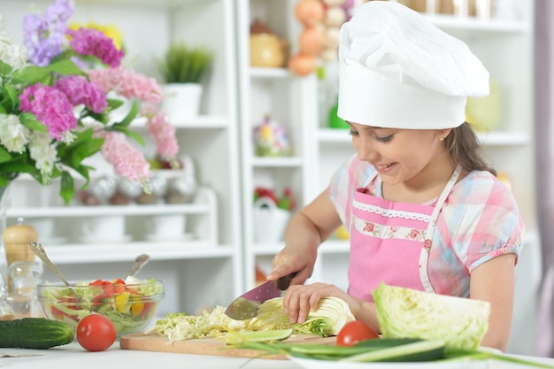 Linda niña haciendo la cena