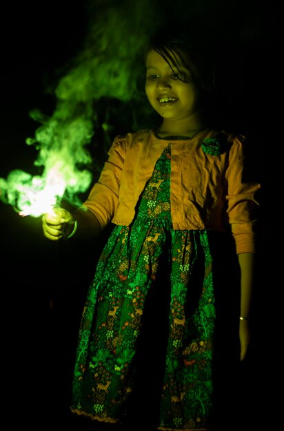 Foto una linda niña india disfrutando de chispas durante el festival de diwali