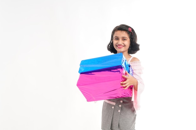 Linda niña india Niño con cajas de regalos en telas tradicionales que se encuentran aisladas sobre fondo blanco