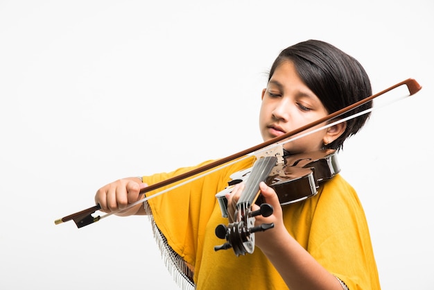 Linda niña india o asiática tocando el violín, aislado sobre fondo blanco.