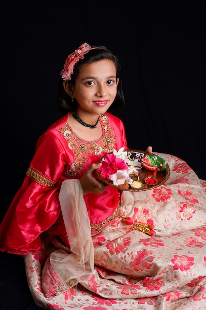 Foto linda niña india sosteniendo diya o lámparas de aceite para la celebración de diwali.