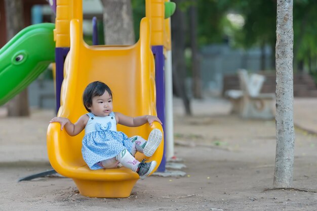 Linda niña juega en el patio de recreoGente tailandesaNiña asiática juega con diversión