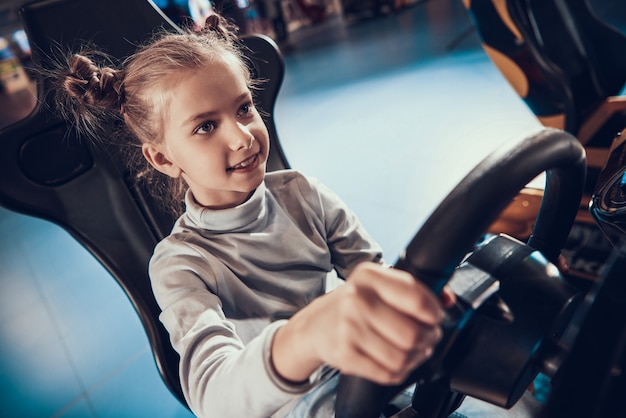 Linda niña jugando al juego simulador de carreras