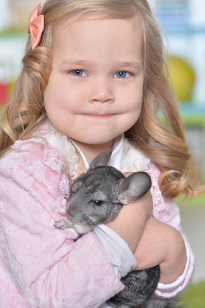 Linda niña jugando con chinchilla