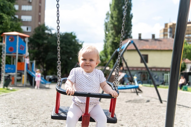 Linda niña jugando en los columpios