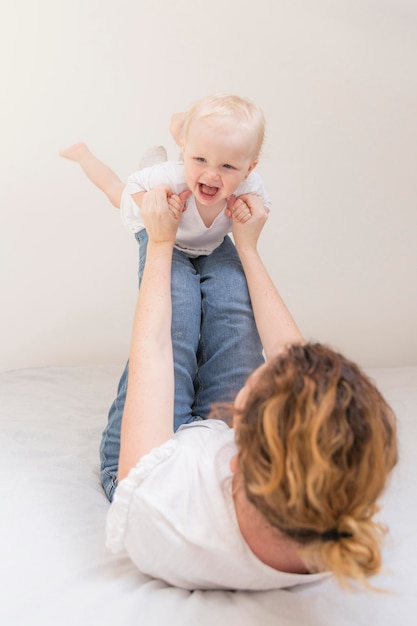 Foto linda niña jugando con la madre en casa