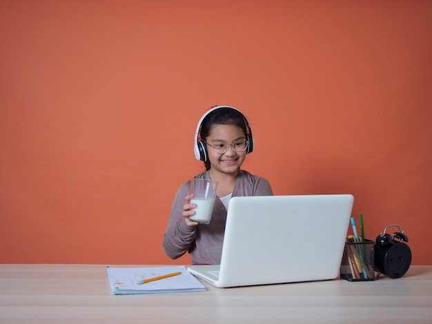 Linda niña con laptop en la mesa