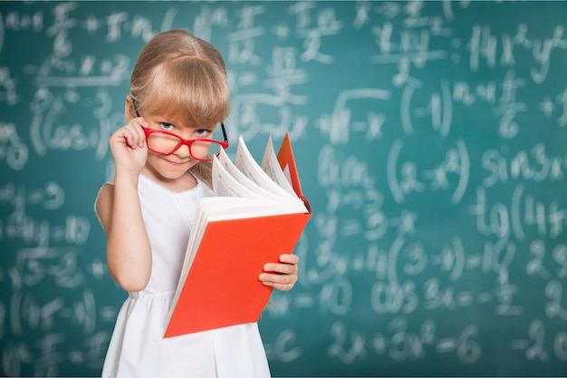 Linda niña con libro sobre fondo