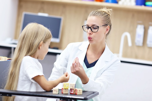 linda niña en la oficina del terapeuta del habla