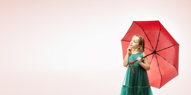 Linda niña con paraguas sobre fondo de color con espacio de copia linda pancarta panorámica de niña pensativa