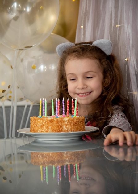 Una linda niña con el pastel House Birthday Atmosphere