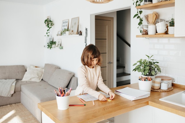 Foto linda niña preescolar aprendiendo en casa aprendizaje a distancia de educación en el hogar para niños