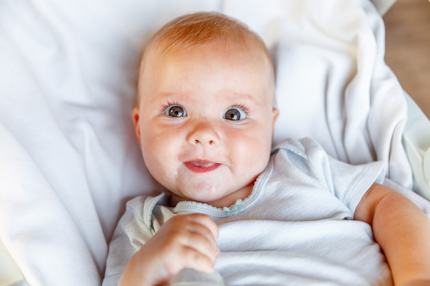 Linda niña recién nacida con cara sonriente mirando a la cámara sobre fondo blanco bebé recién nacido descansando ...