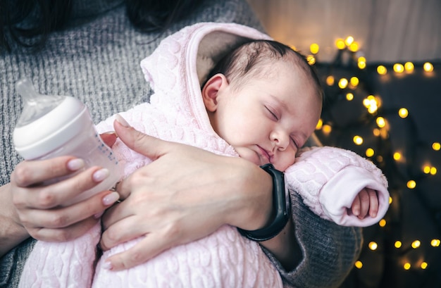 Una linda niña recién nacida duerme en los brazos de su madre