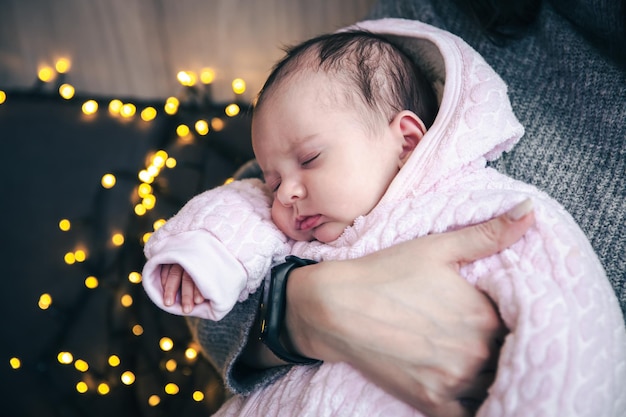 Una linda niña recién nacida duerme en los brazos de su madre