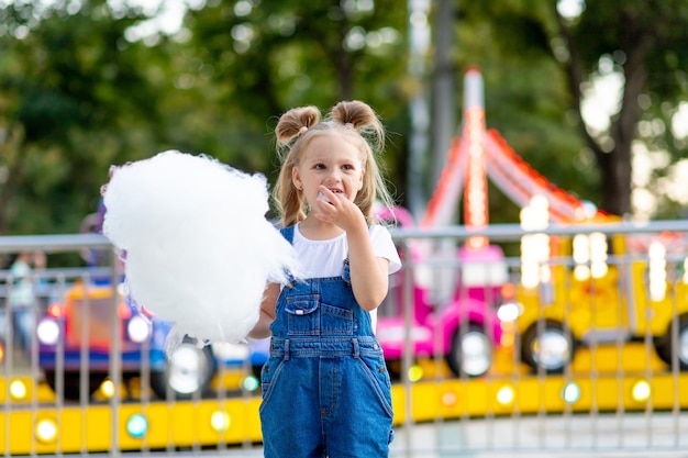 Linda niña rubia en un parque de atracciones