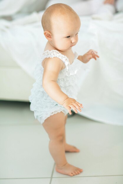 Linda niña sonriente aprendiendo a caminar