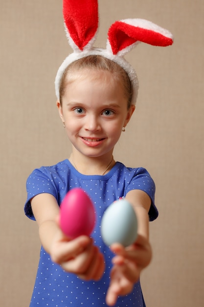 Linda niña sonriente con coloridos huevos de Pascua. Felices Pascuas. enfoque selectivo