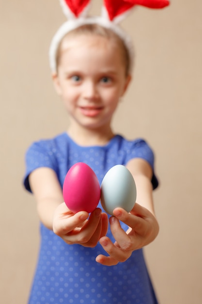 Linda niña sonriente con coloridos huevos de Pascua. Felices Pascuas. enfoque selectivo